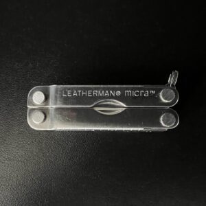 Closed Stainless steel Leatherman Micra with black background