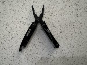 Small Black Keychain Multitool Gerber Dime in the open position with the pliers pointed up