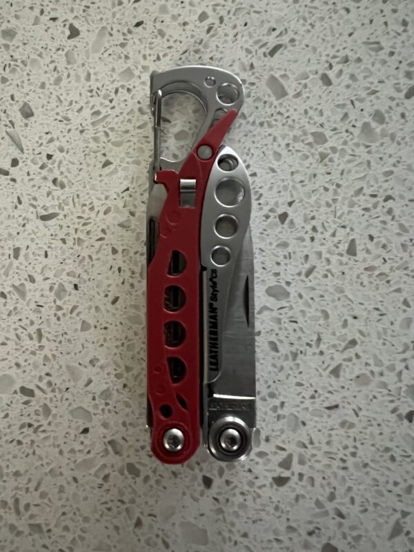 Red Leatherman Style PS in the closed position with the carabiner facing upward