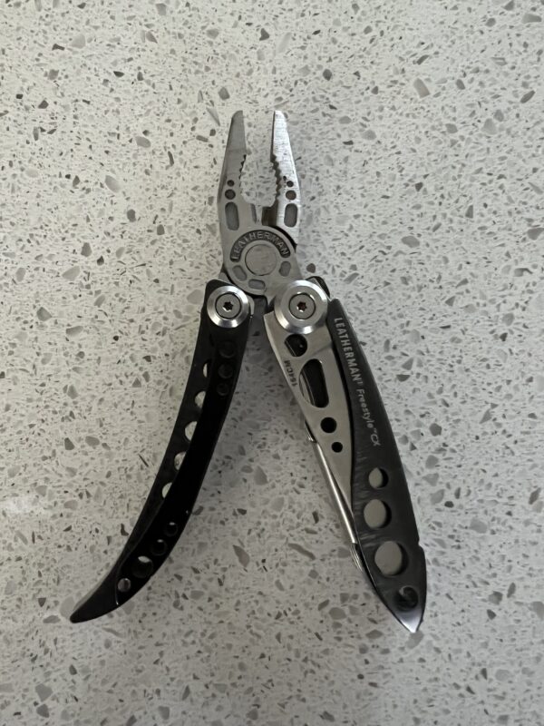 Leatherman Freestyle CX Black with pliers out and pointed up. Butterfly style opening