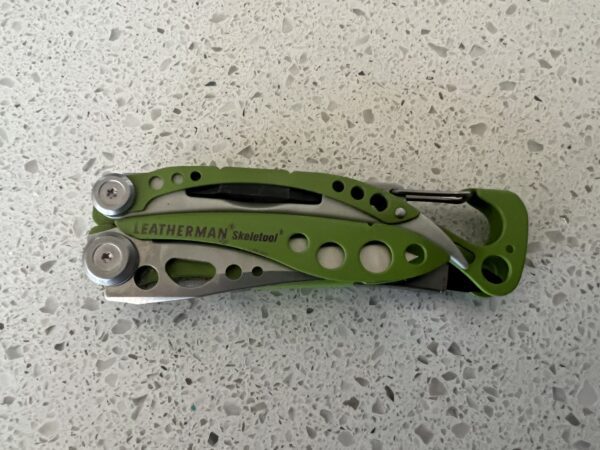 Green Skeletool in the closed position with the caribiner to the right