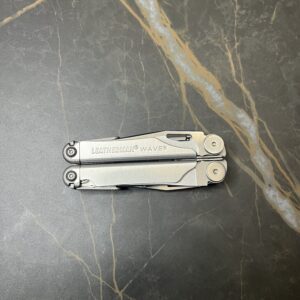 Stainless Steel Leatherman Wave 2nd Generation, closed position on a black marble table