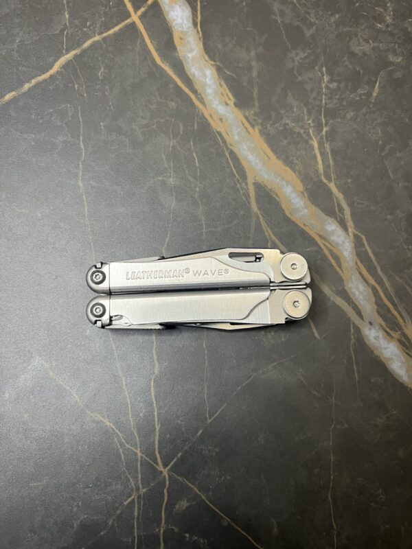 Stainless Steel Leatherman Wave 2nd Generation, closed position on a black marble table