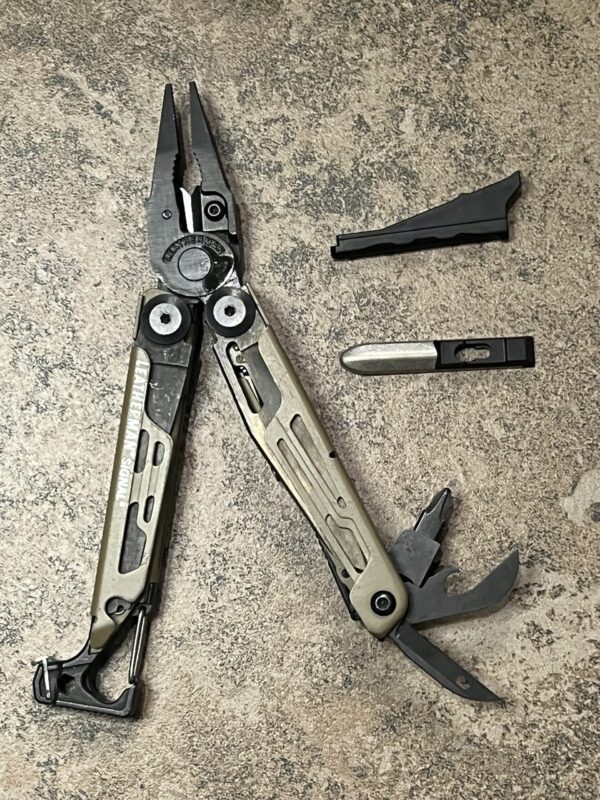 Tan Leatherman Signal with Pliers open and tools fanned open