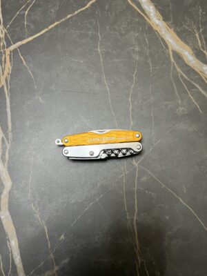 Sunrise Orange Leatherman C2 in the closed position with the lanyard ring sticking out on the left side