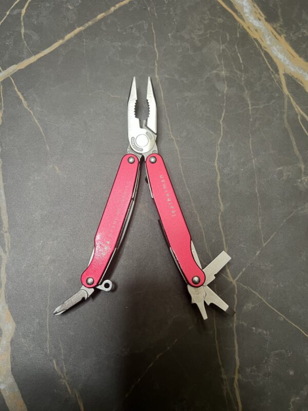 Red Leatherman Juice C2 with pliers and inside handle tools fanned